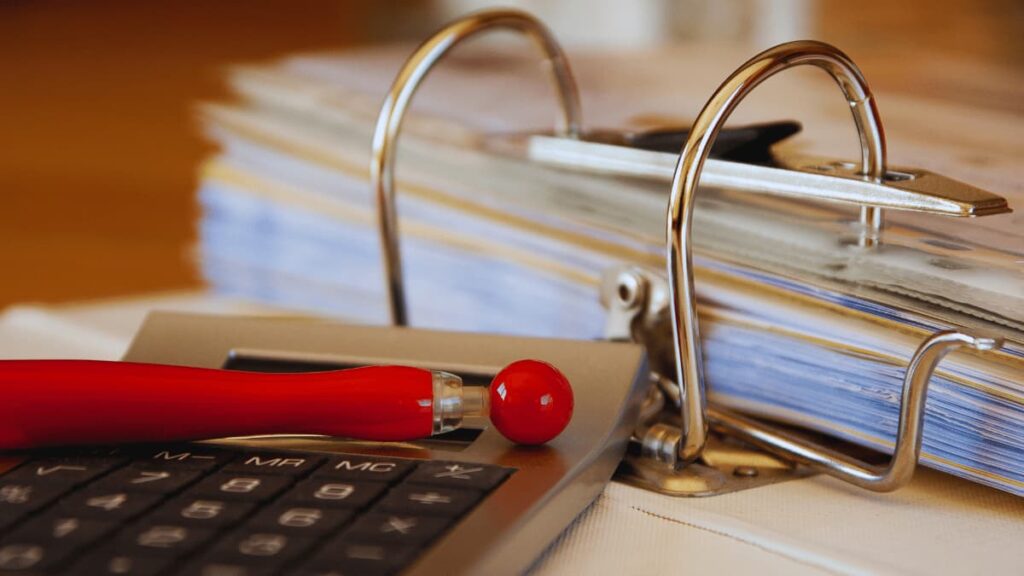 Administratieve setting met rekenmachine en facturen in beeld.